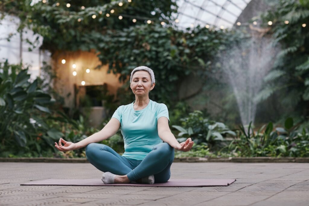 Woman meditating and doing yoga thanks to using CBD for exercise. 