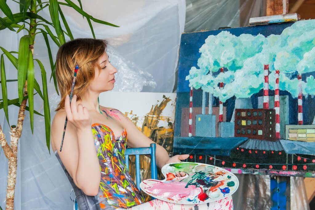 Woman painting at home after taking the best cannabis strains to boost creativity. 