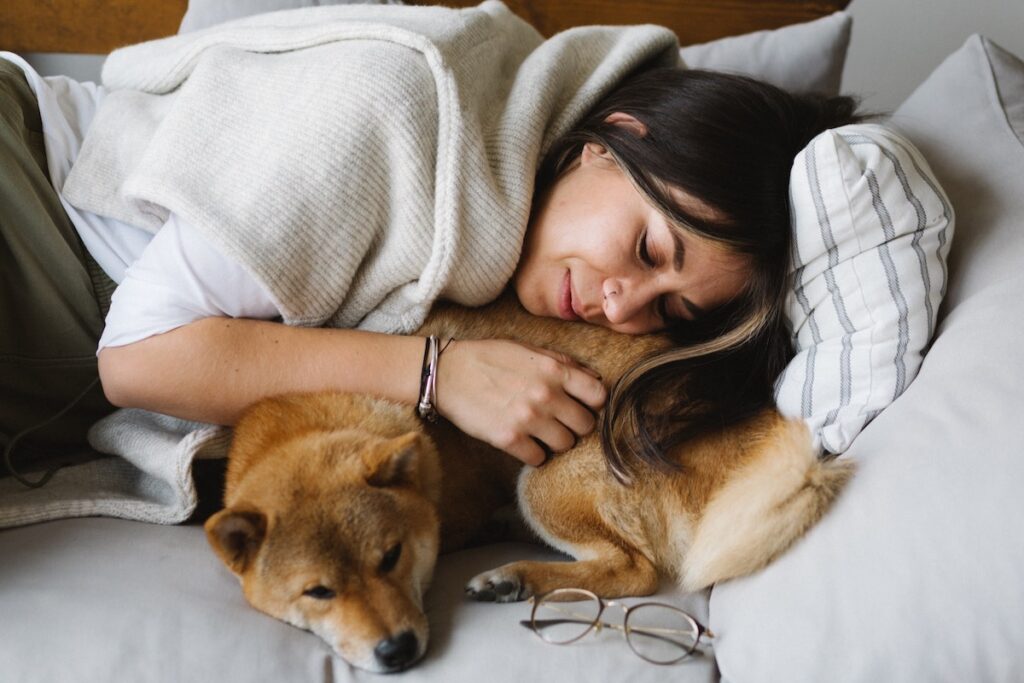Woman resting next to her dog after taking the best cannabis strains for rest and relaxation. 