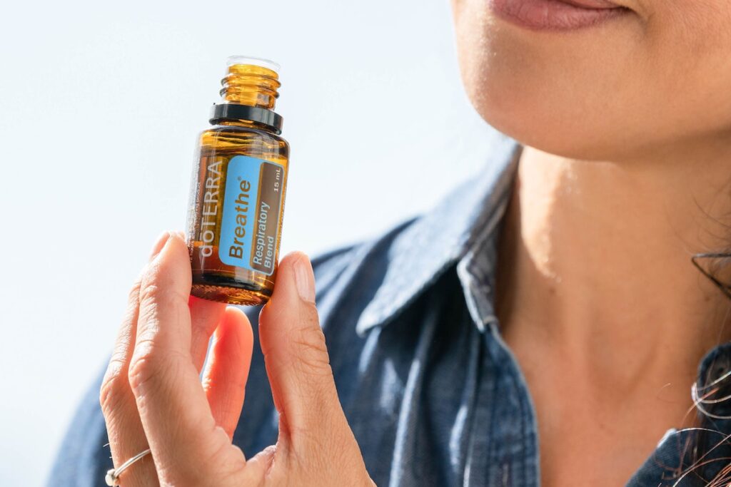 Woman inhaling doTERRA's Breathe essential oil. 