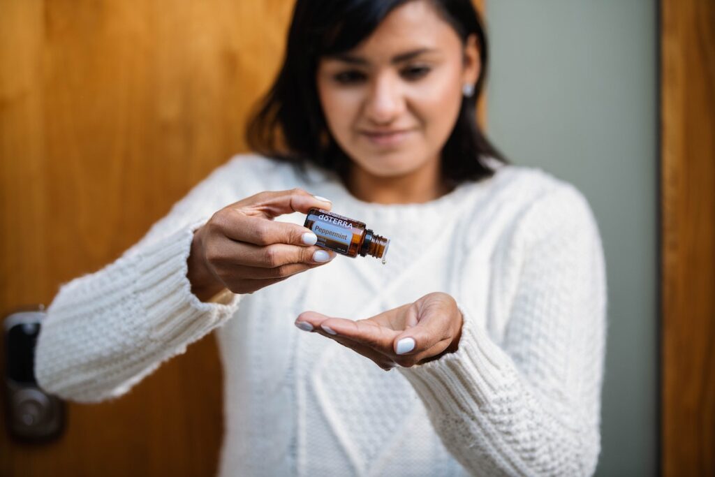 Woman pouring essential oils into her hand. 