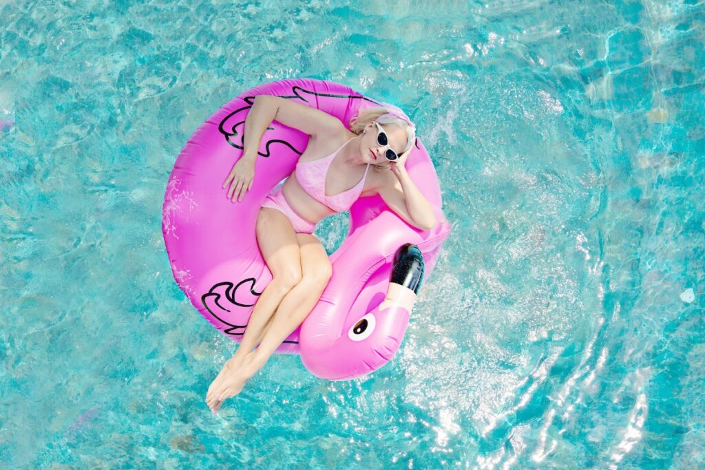 Woman lounging in a pool in a floaty to relax. 