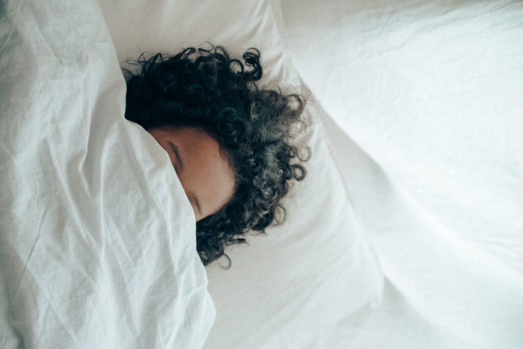 Woman asleep and under the covers. 