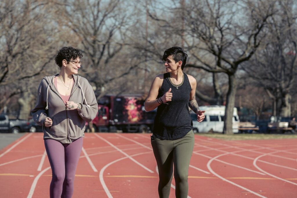 Another reason to run is to socialize with friends — these two women are running together on a track. 