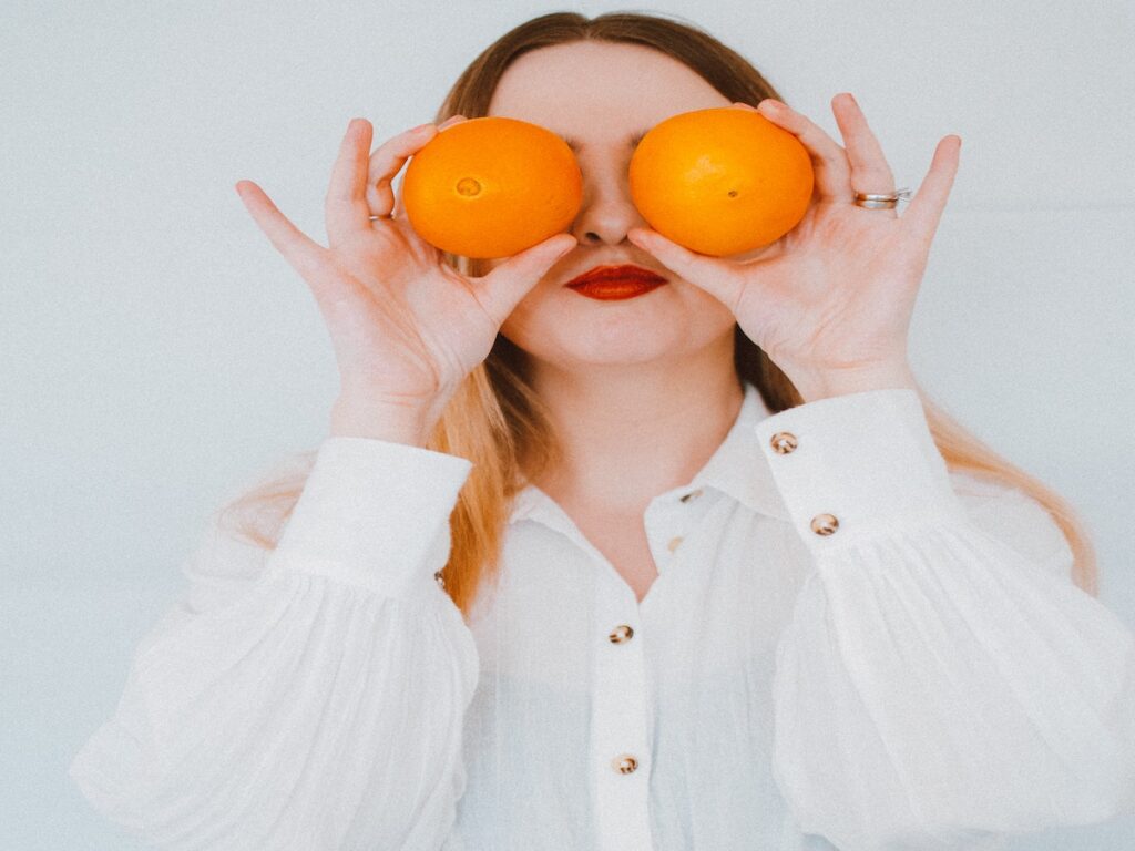 Woman holding Vitamin D heavy oranges. 