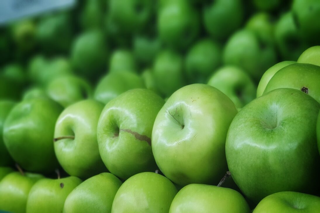 Green apples lined up together. 