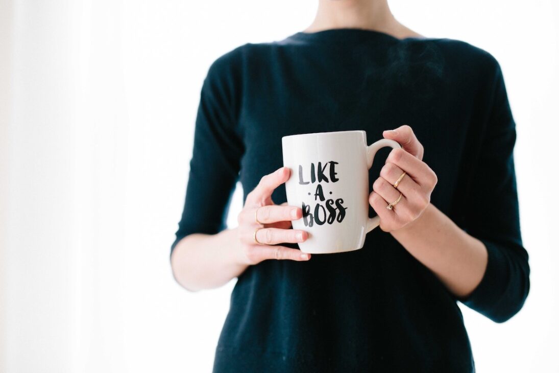Woman holding a "like a boss" coffee mug. 