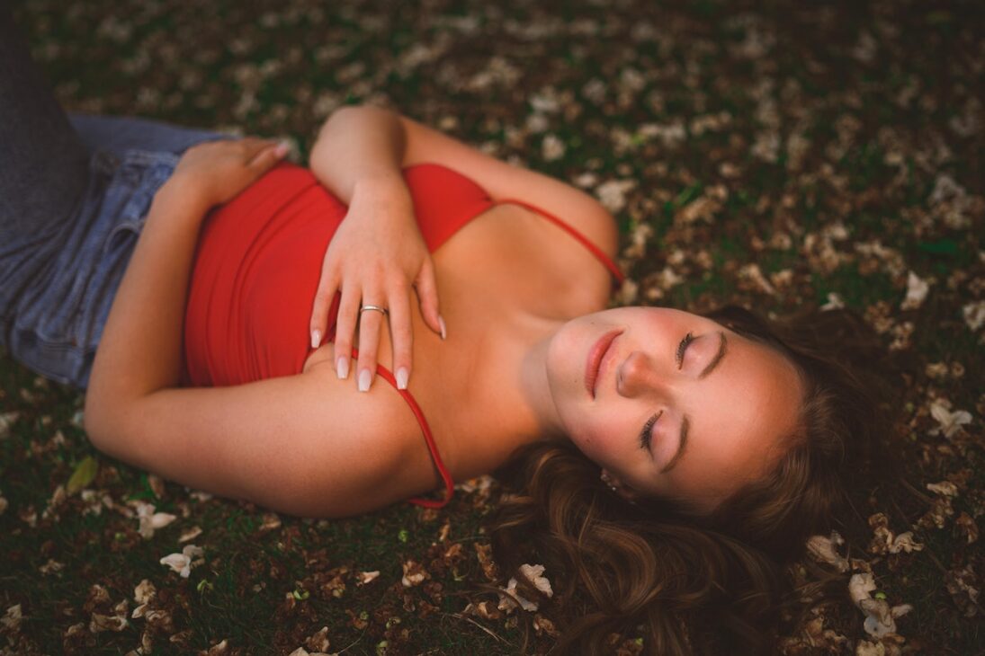 Woman lying on the ground meditating.