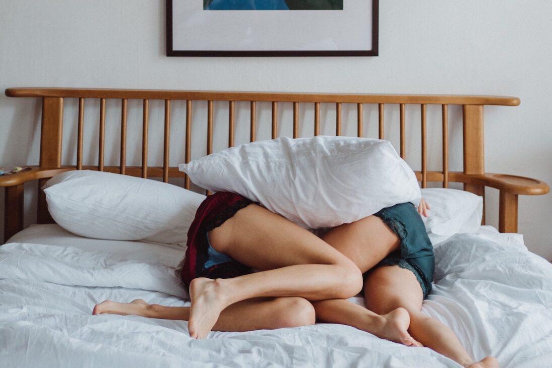 Two people cuddling in bed. 