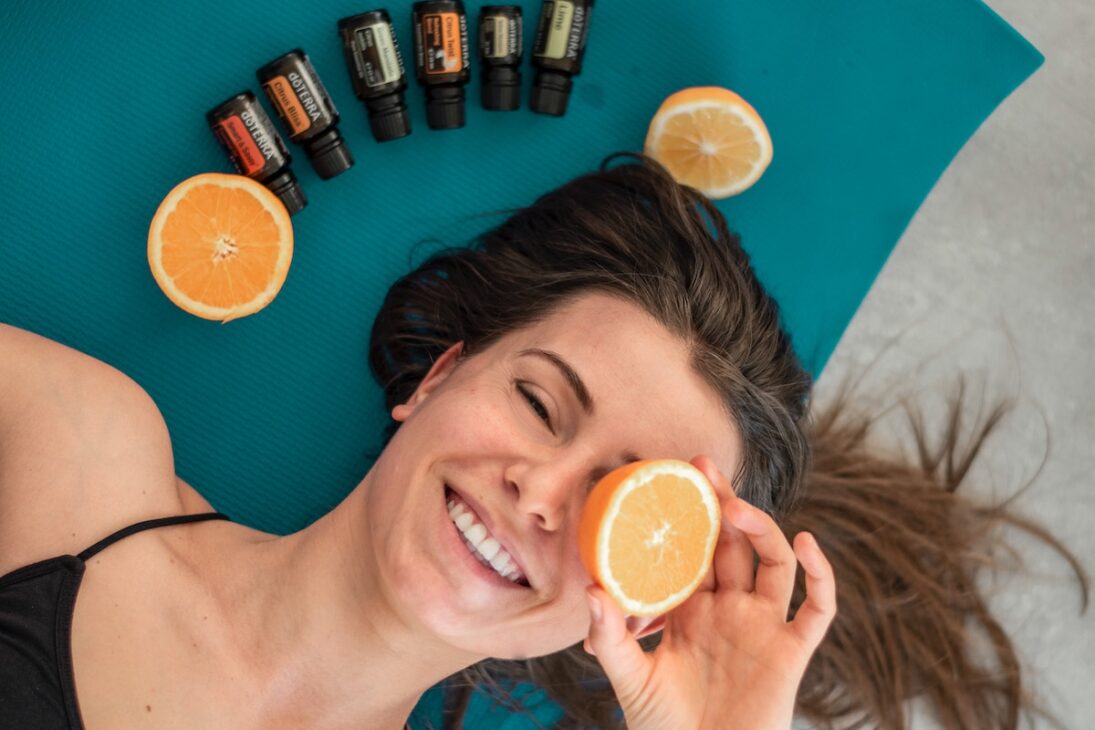 Woman on a yoga mat with the essential oils for travel that she brought with her. 