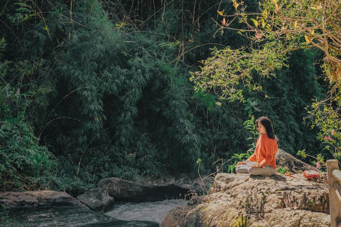 Woman meditating outside in nature while celebrating 420. 